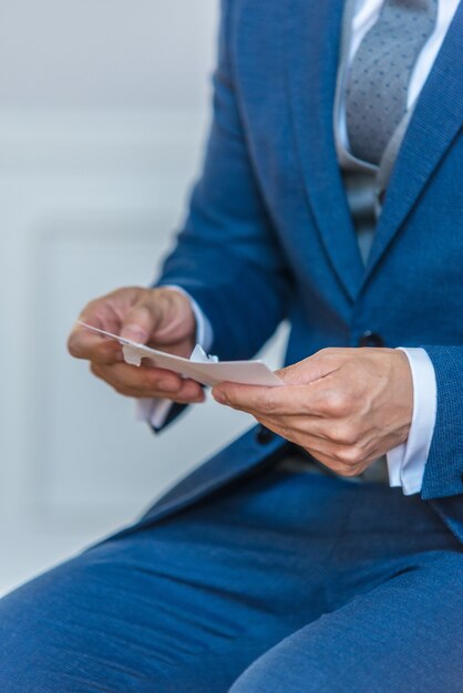 Primer plano vertical de un novio en un elegante traje azul