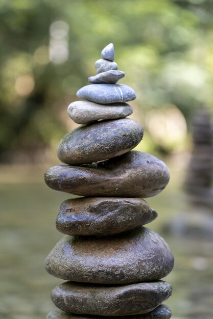 Primer plano vertical de una pirámide de piedras en equilibrio sobre el agua de un río