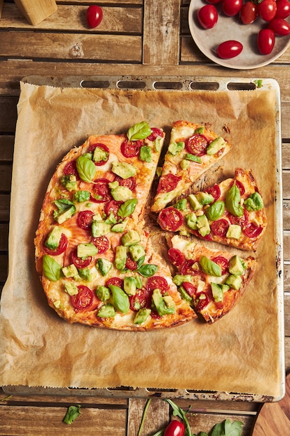 Foto gratuita primer plano vertical de una pizza con verduras en la mesa de madera