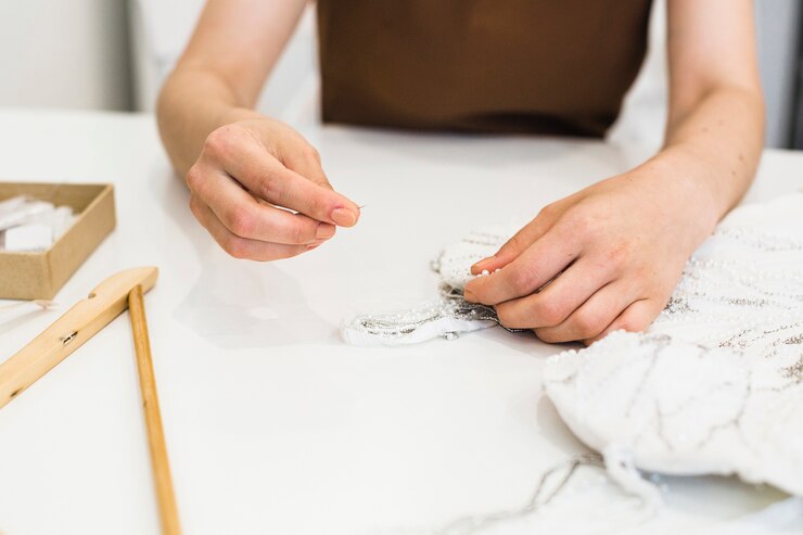 Foto gratuito primer plano del vestido de coser a mano del diseñador de moda sobre el escritorio