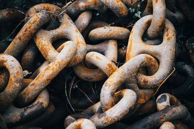 Primer plano de viejas cadenas metálicas oxidadas bajo las luces