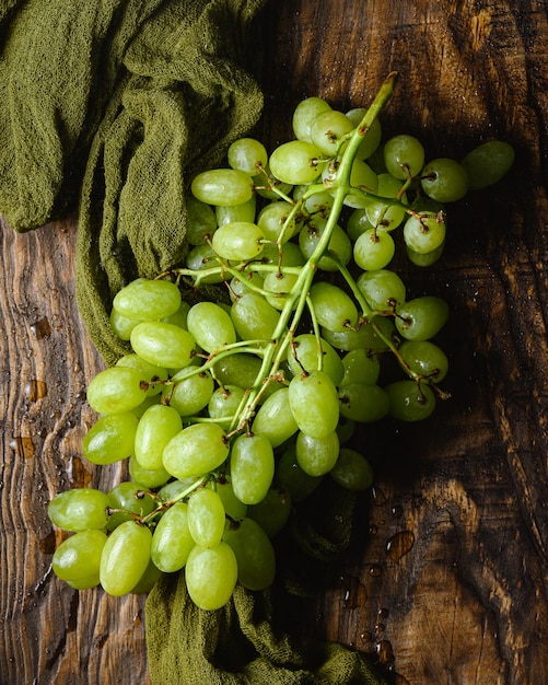 Foto gratuita primer plano de vista superior de uvas verdes en la mesa de madera