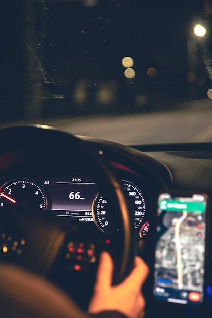 Primer plano del volante y el navegador en un coche de noche