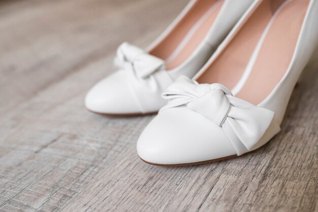 Primer plano de los zapatos de vestir de la novia en el fondo con textura de madera
