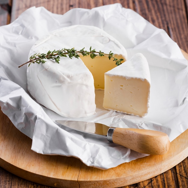 Foto gratuita primer trozo de queso con cuchillo