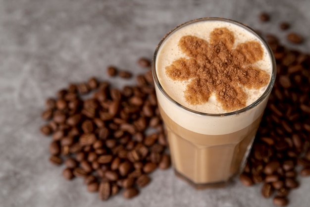 Primer vaso de café con leche con granos tostados