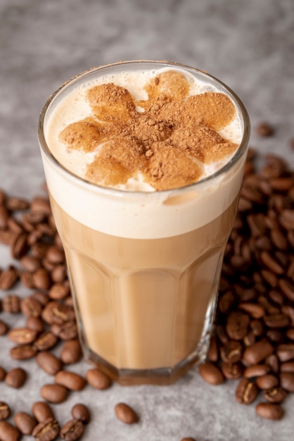 Primer vaso de capuchino con granos de café