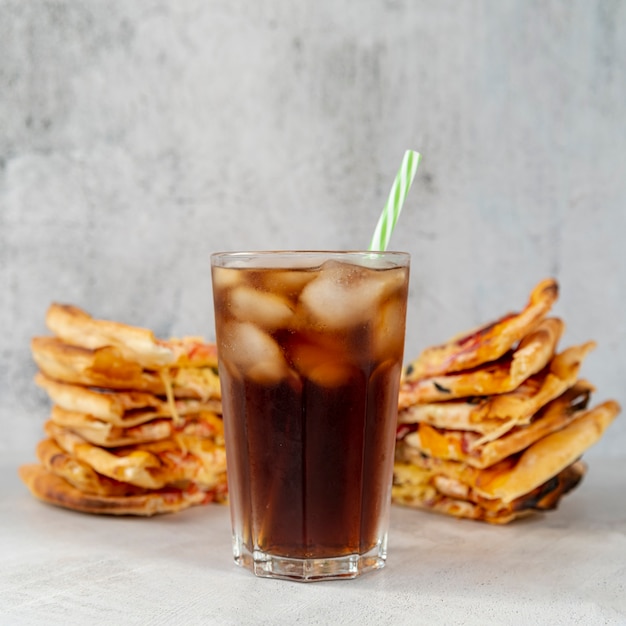 Primer vaso de refresco con rebanadas de pizza