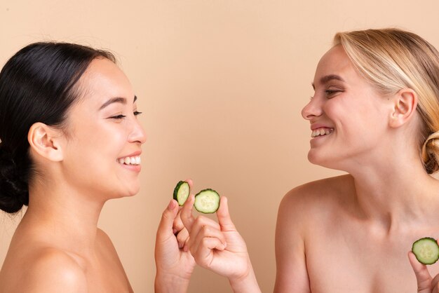 Foto gratuita primeros modelos felices posando con rodajas de pepino