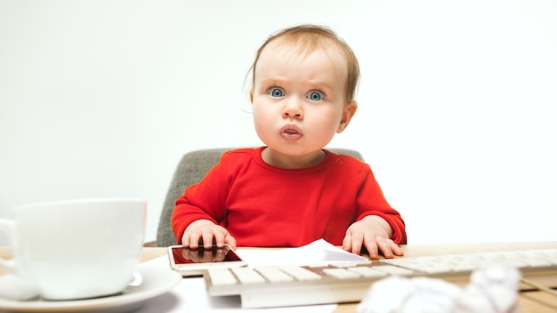 Foto gratuita primeros sms. niño niña sentada con el teclado de la computadora moderna o portátil en blanco