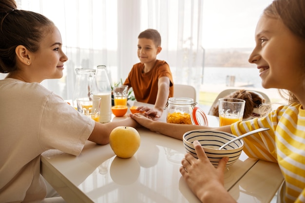 Foto gratuita primos pasando tiempo juntos en casa y desayunando