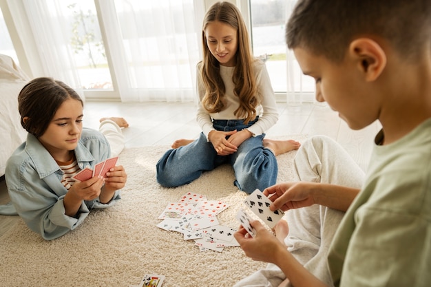 Primos pasando tiempo juntos en casa y jugando a las cartas