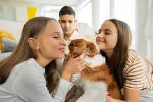 Foto gratuita primos pasando tiempo juntos en casa con un perro mascota