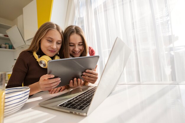 Primos que pasan tiempo juntos en casa con una laptop