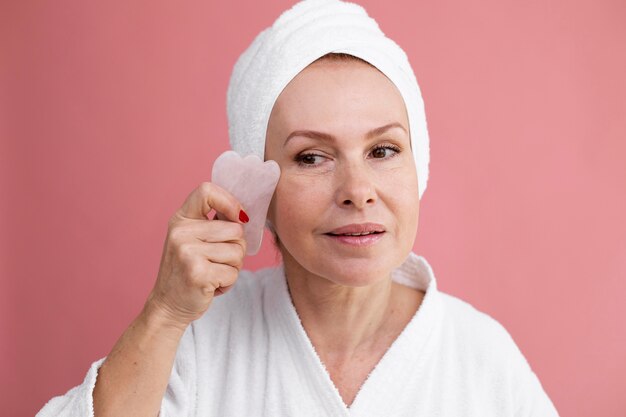 Procedimiento de cara de gua sha en curso de mujer