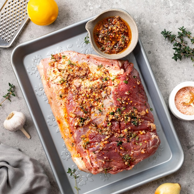 El proceso de cocinar porchetta casera a partir de carne de cerdo cruda.