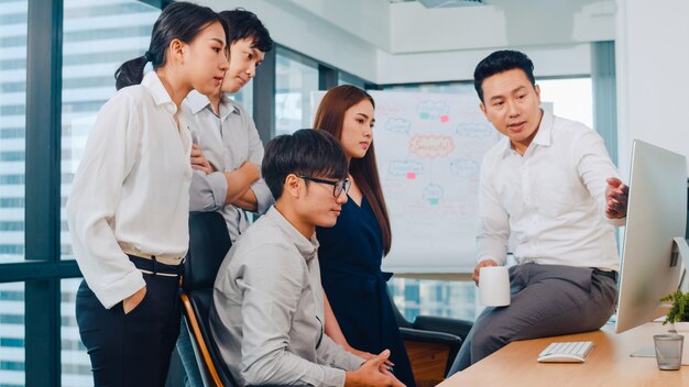 Proceso de colaboración de empresarios multiculturales que utilizan la presentación por computadora y la comunicación para encontrar ideas de lluvia de ideas sobre los colegas del proyecto y la estrategia de éxito del plan de trabajo en la oficina moderna.