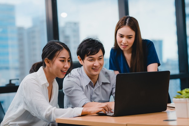 Proceso de colaboración de empresarios multiculturales que utilizan la presentación y la comunicación de una computadora portátil para reunir ideas de lluvia de ideas sobre los colegas del proyecto y la estrategia de éxito del plan de trabajo en la oficina moderna