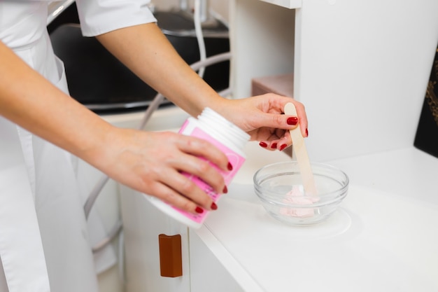 El proceso de elaboración de una mascarilla de alginato rosa para la cara y el cuello.