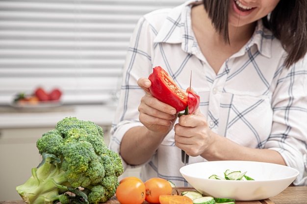 El proceso de preparación de una ensalada vegetariana. Concepto de dieta y comida sana.