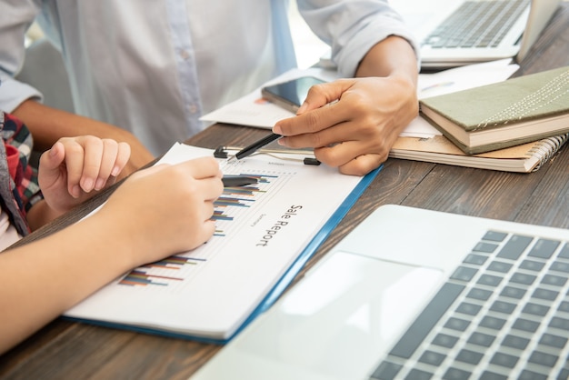 Proceso de trabajo en equipo. empresarios discutiendo los cuadros y gráficos que muestran los resultados de su cooperación exitosa