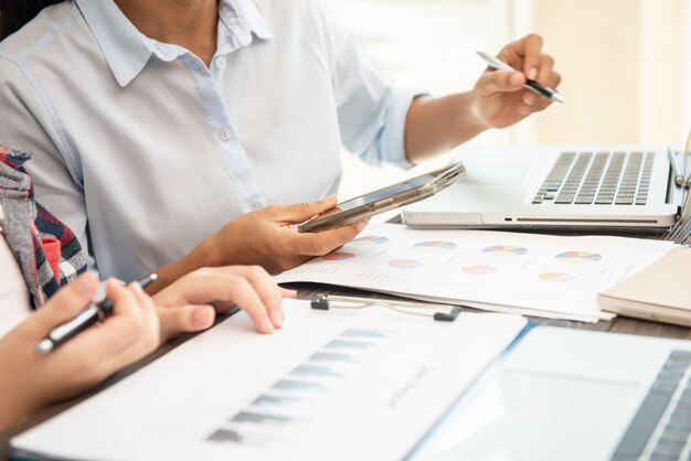 Proceso de trabajo en equipo. empresarios discutiendo los cuadros y gráficos que muestran los resultados de su cooperación exitosa