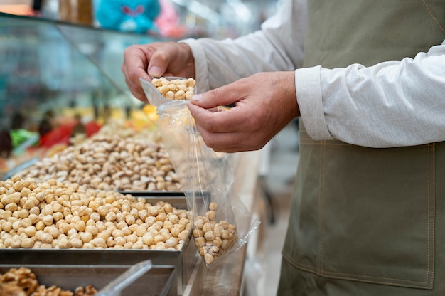 Productor masculino en su tienda con diferentes golosinas.