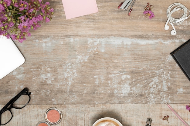 Productos cosméticos; Accesorios personales con planta dispuesta sobre mesa de madera.