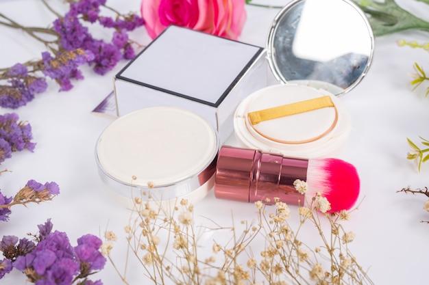 Foto gratuita productos cosméticos y flores en blanco