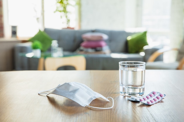 Foto gratuita productos esenciales durante la epidemia: prevención y protección de la propagación del coronavirus. protege el sistema respiratorio contra la neumonía, covid-19. desinfectantes, mascarilla, pastillas de mesa de madera.