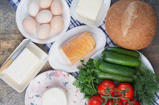 Productos lácteos, pan y verduras para el desayuno.