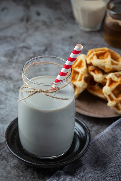 Productos lácteos sabrosos productos lácteos saludables en una mesa de crema agria en un tazón, tazón de requesón, crema en un banco y tarro de leche, botella de vidrio y en un vaso.