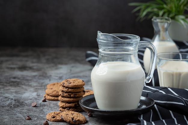 Productos lácteos sabrosos productos lácteos saludables en una mesa de crema agria en un tazón, tazón de requesón, crema en un banco y tarro de leche, botella de vidrio y en un vaso.