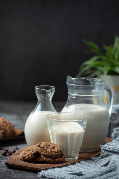 Productos lácteos sabrosos productos lácteos saludables en una mesa de crema agria en un tazón, tazón de requesón, crema en un banco y tarro de leche, botella de vidrio y en un vaso.