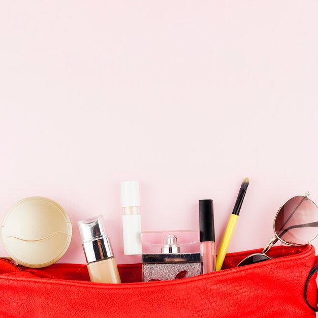 Productos de maquillaje en bolsa roja