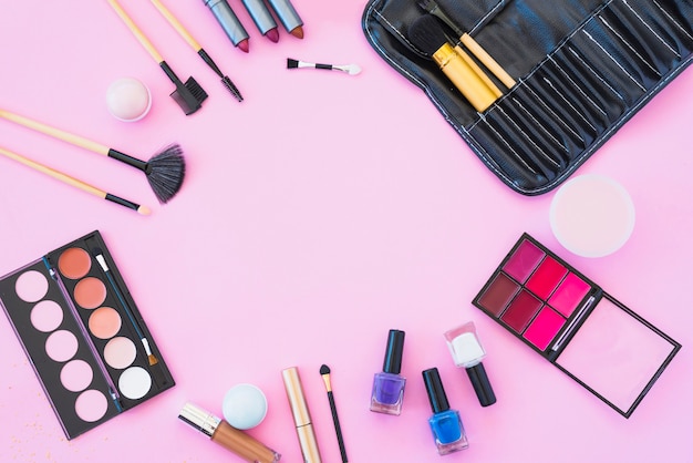 Productos de maquillaje profesional con productos de belleza estética sobre fondo rosa.