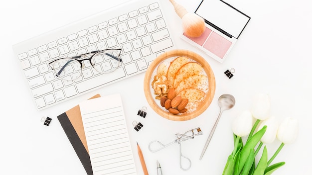 Foto gratuita productos de maquillaje y tazón con yogurt en la oficina