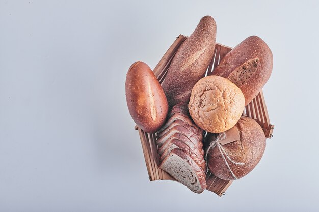 Productos de panadería en mesa blanca en una canasta de madera.