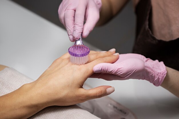 Profesional del arte de las uñas trabajando en las uñas de los clientes