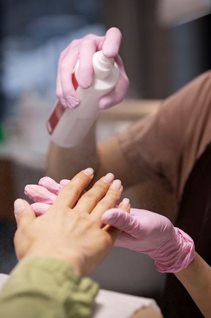 Profesional del arte de las uñas trabajando en las uñas de los clientes