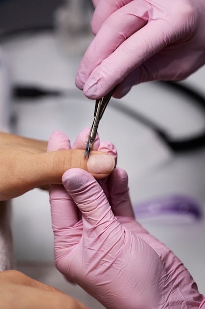 Profesional del arte de las uñas trabajando en las uñas de los clientes