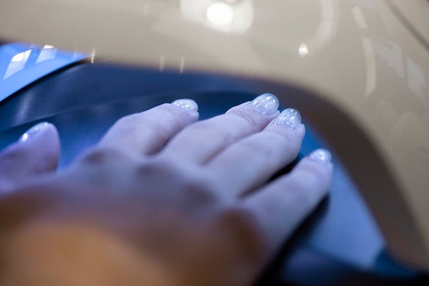 Profesional del arte de las uñas trabajando en las uñas de los clientes