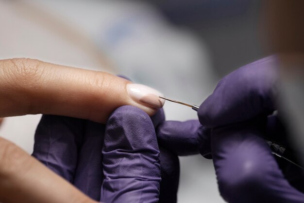 Profesional del arte de las uñas trabajando en las uñas de los clientes