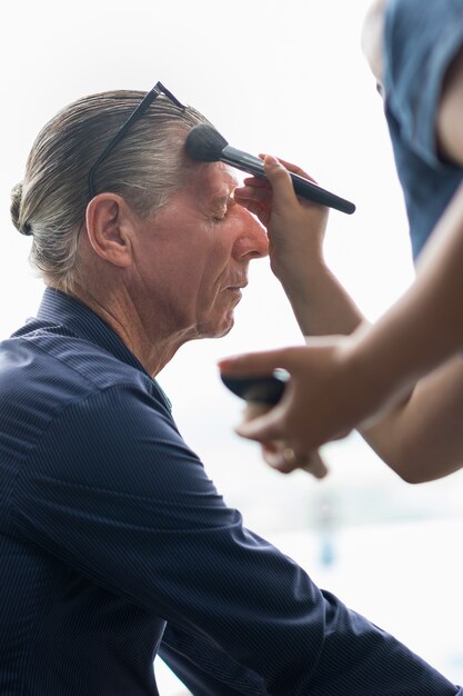 Profesional del artista de maquillaje de la cara Haciendo hombre mayor