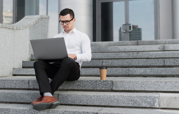 Profesional buscando en la computadora portátil al aire libre