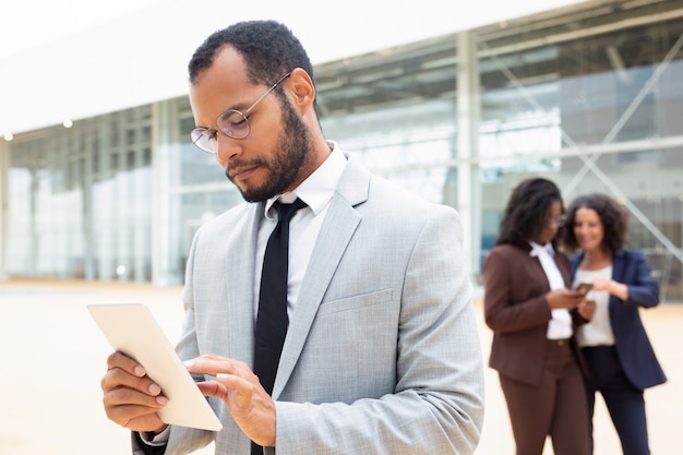 Profesional de negocios masculino enfocado usando tableta