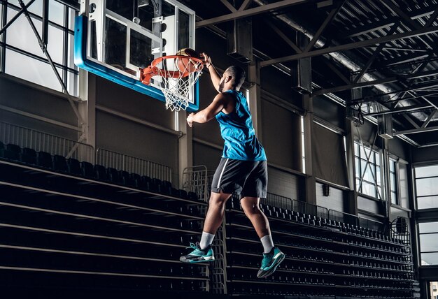 Profesional negro Jugador de baloncesto negro en acción en una cancha de baloncesto.