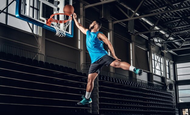 Profesional negro Jugador de baloncesto negro en acción en una cancha de baloncesto.