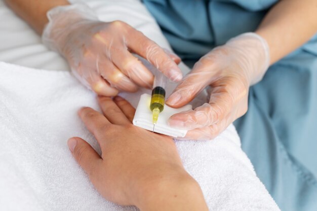 Profesional de la salud de alto ángulo que inyecta la mano