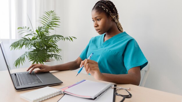 Profesional de la salud de tiro medio en el escritorio